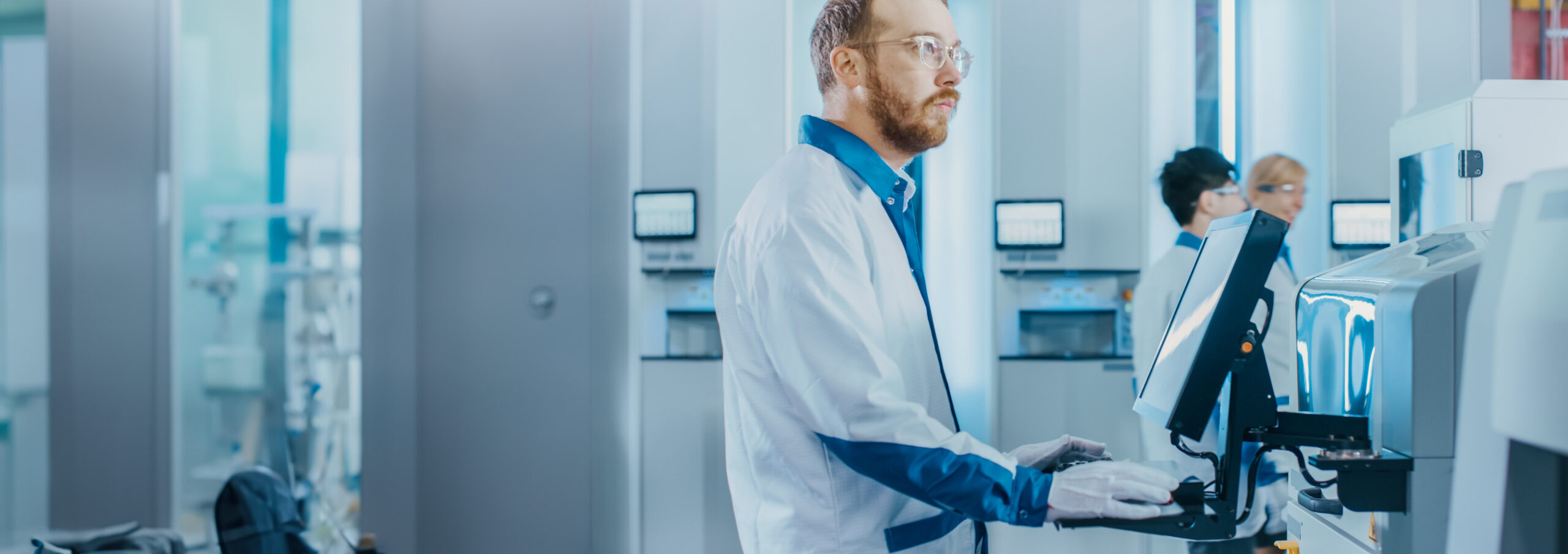 Man in a lab coat in front of a computer workstation