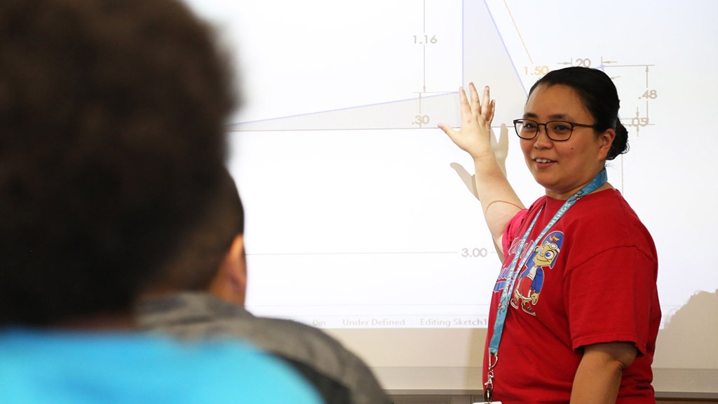 A teacher at a Smart-Board that displays various triangles on it