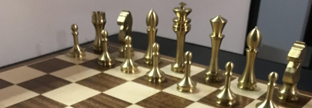 Half of a wooden chess board with gold pieces