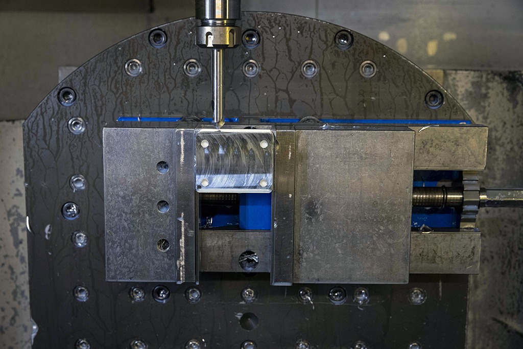 Silver metal actuator block in Mazak's machine using 3+2 milling strategy