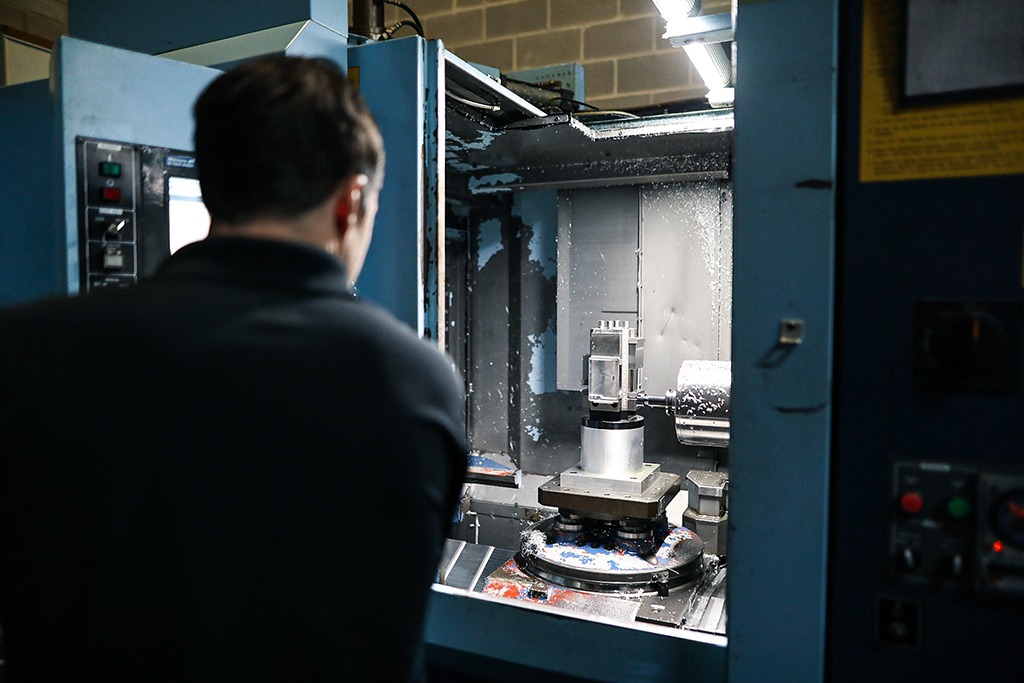 A man watching a non-mag wallet being produced