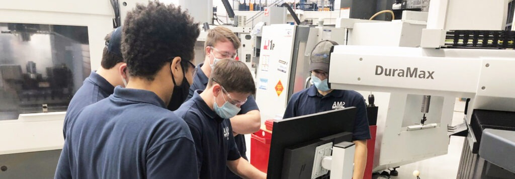 5 male Calhoun students wearing face masks and safety goggles using mastercam dura max software