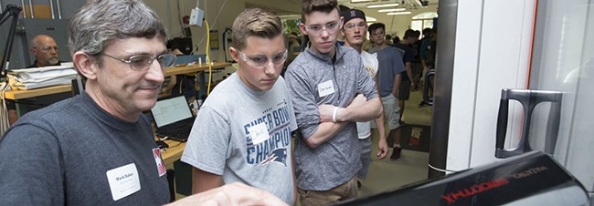 Photo of students learning how to use a machine