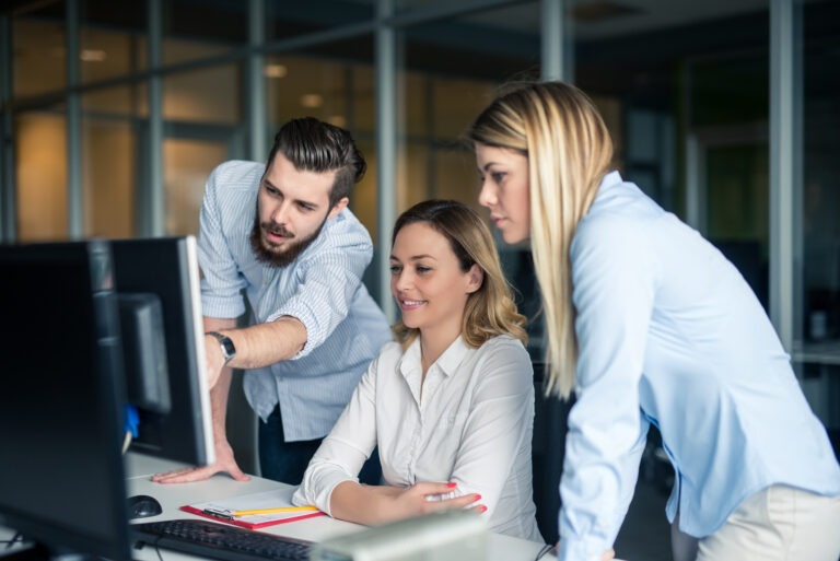 Photo of a small group collaborating around a computer